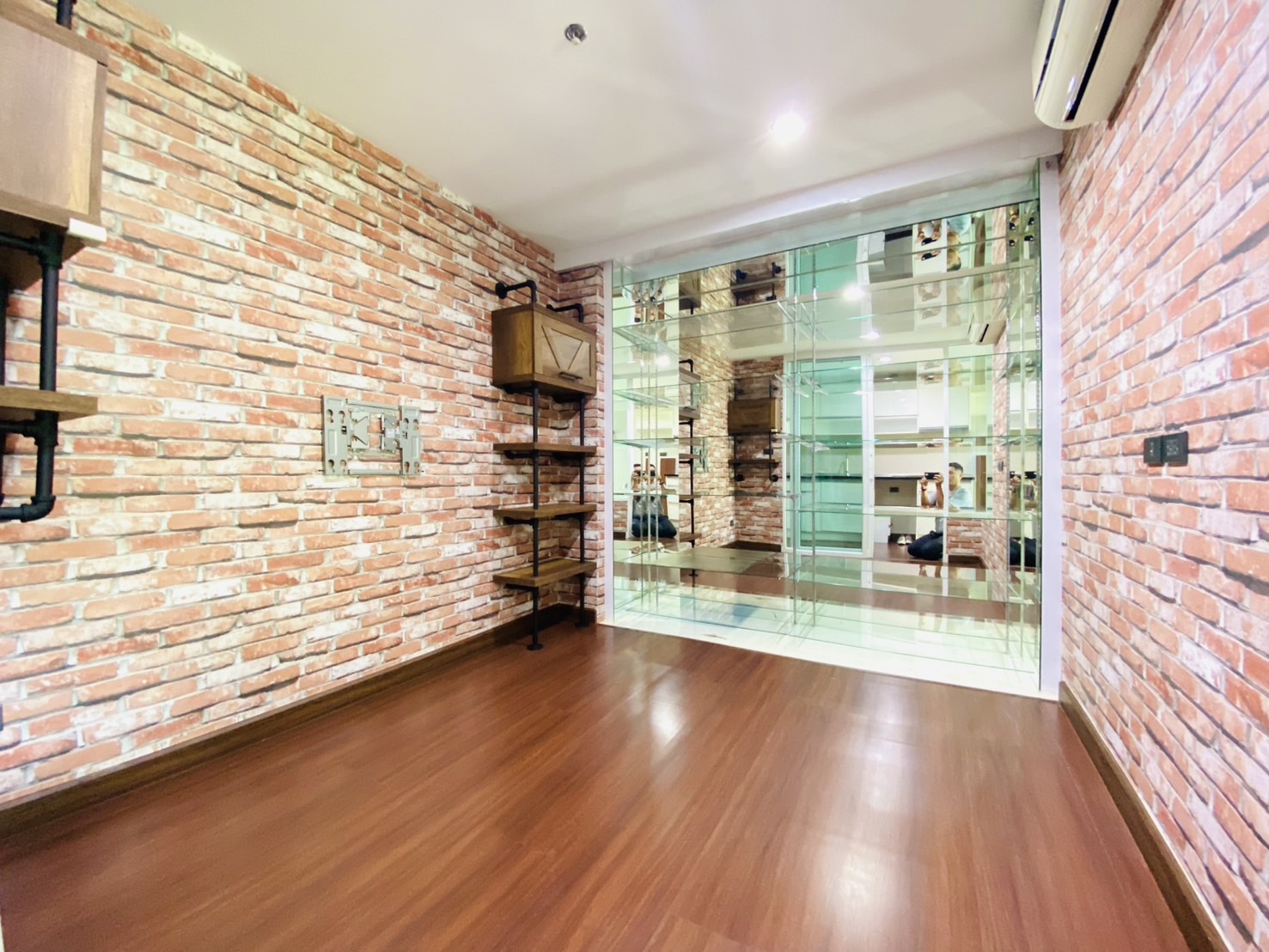 ห้องแบบ 1 bed plus ห้องนอนเล็กตกแต่งด้วยชั้นวางกระจกขนาดใหญ่ สำหรับวางของตกแต่ง